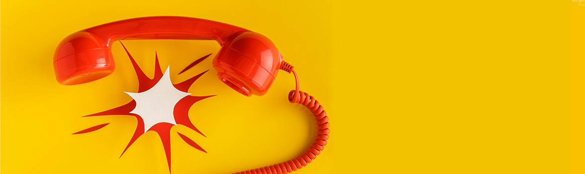 Na ż&oacute;łtym tle jest widoczny czerwona słuchawka.