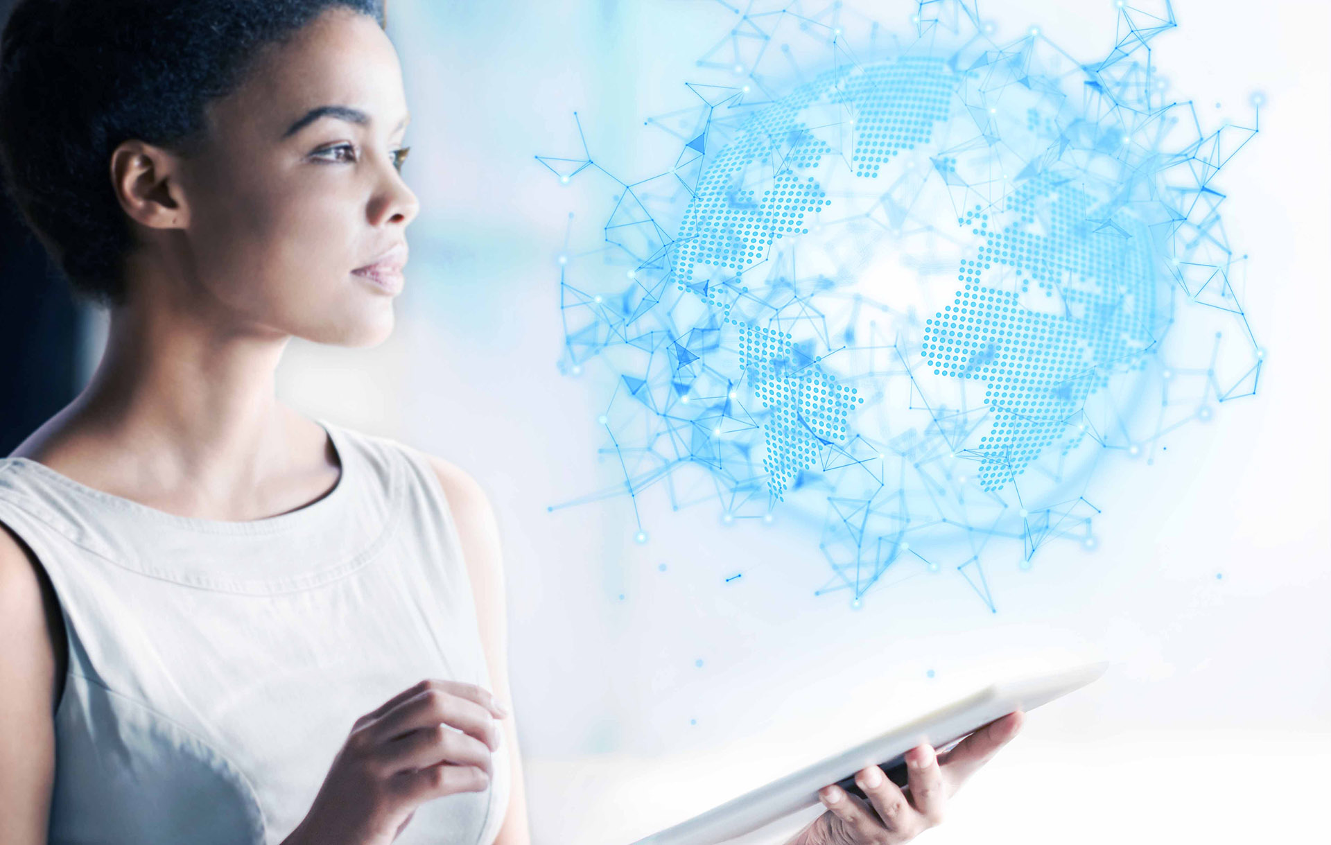 Ciemnosk&oacute;ra kobieta w średnim trzyma w ręce tablet i patrzy na abstrakcyjną sferę przypominającą kulę ziemską