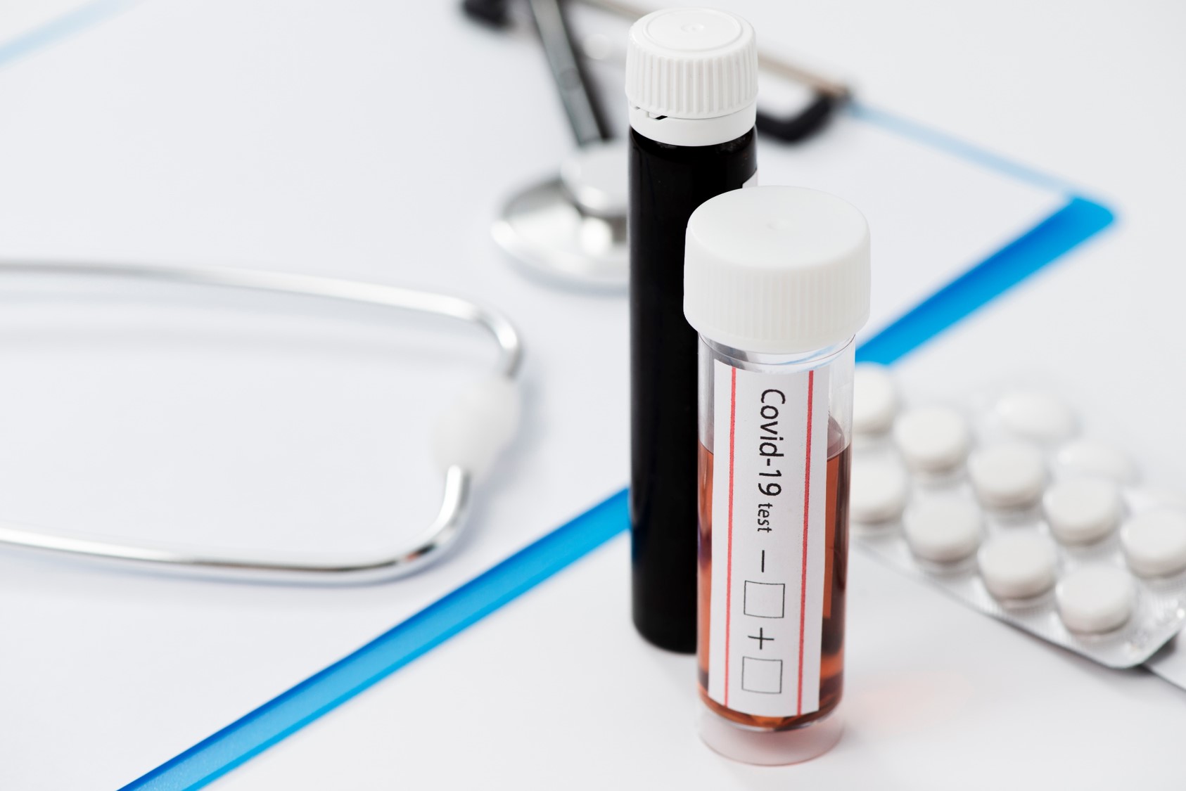 Pr&oacute;bki z krwią do badania, z prawej strony tabletki, z lewej strony widać stetoskop. 