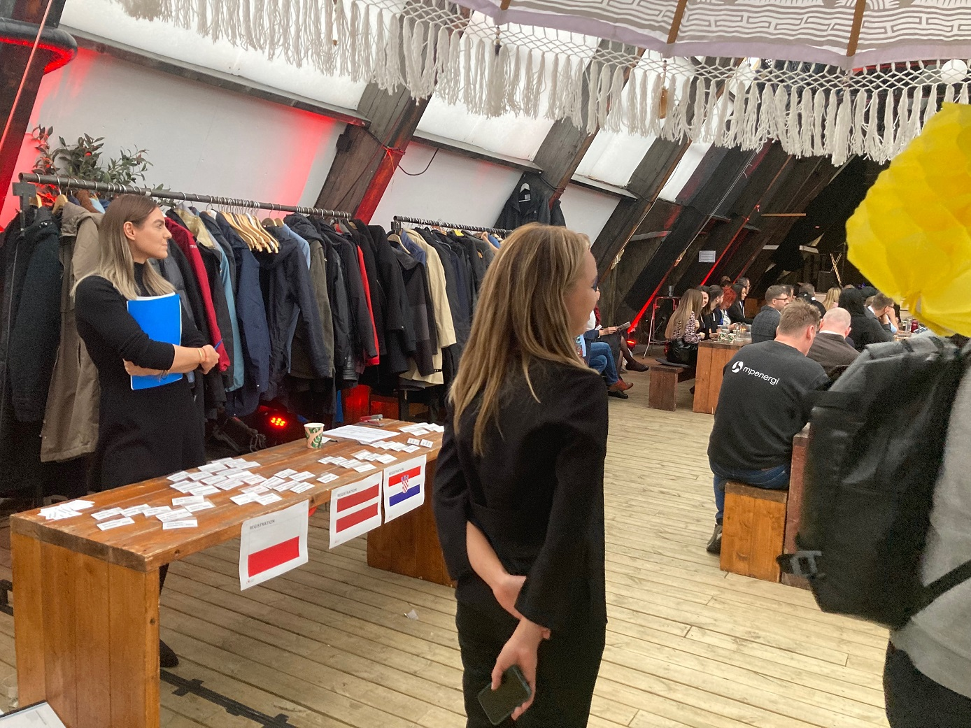 Ujęcie na drewniany blat przy kt&oacute;rym stoi młoda kobieta