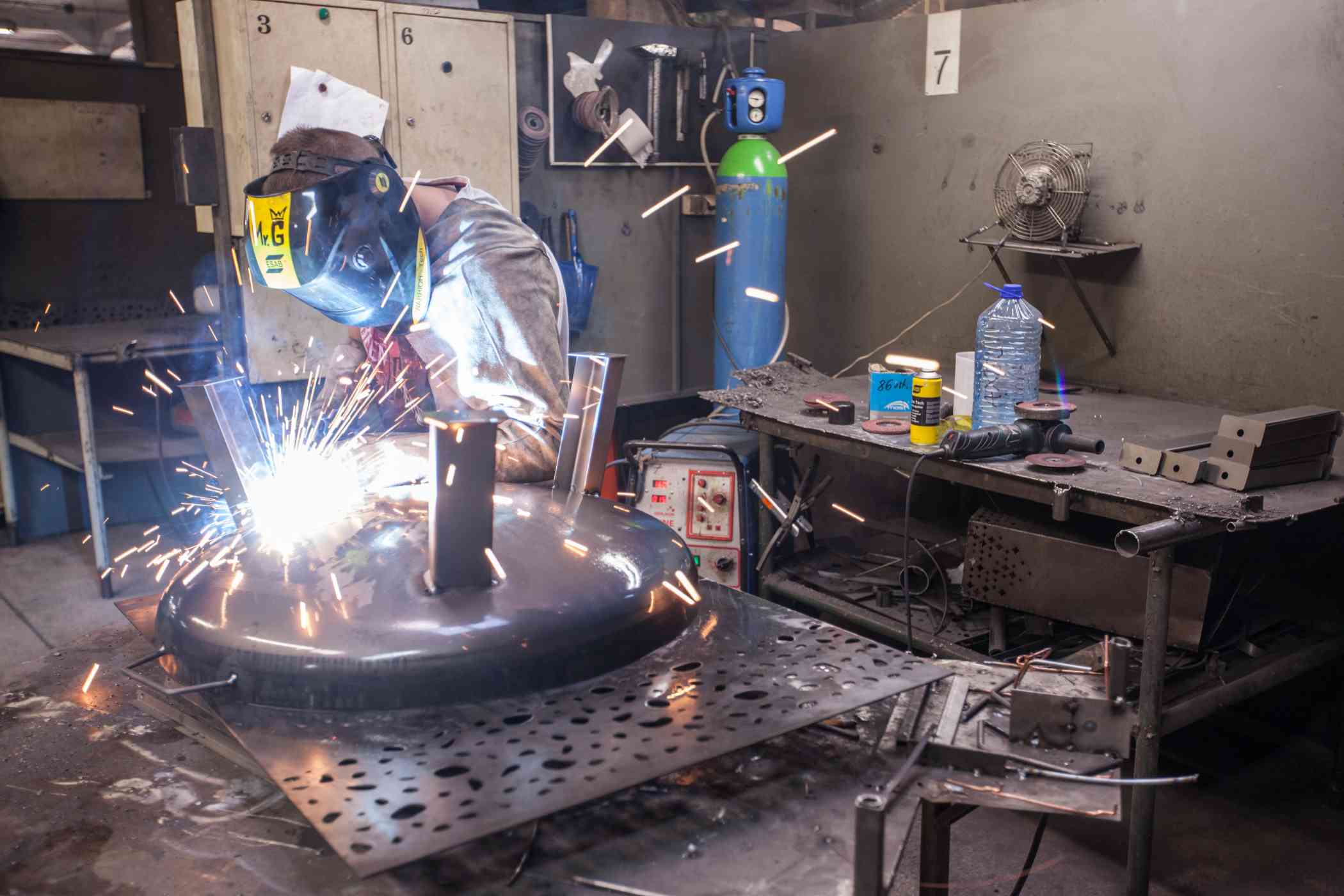 Mężczyzna spawa urządzenia metalowe