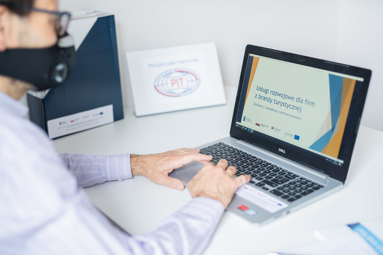 Mężczyzna siedzący przed laptopem