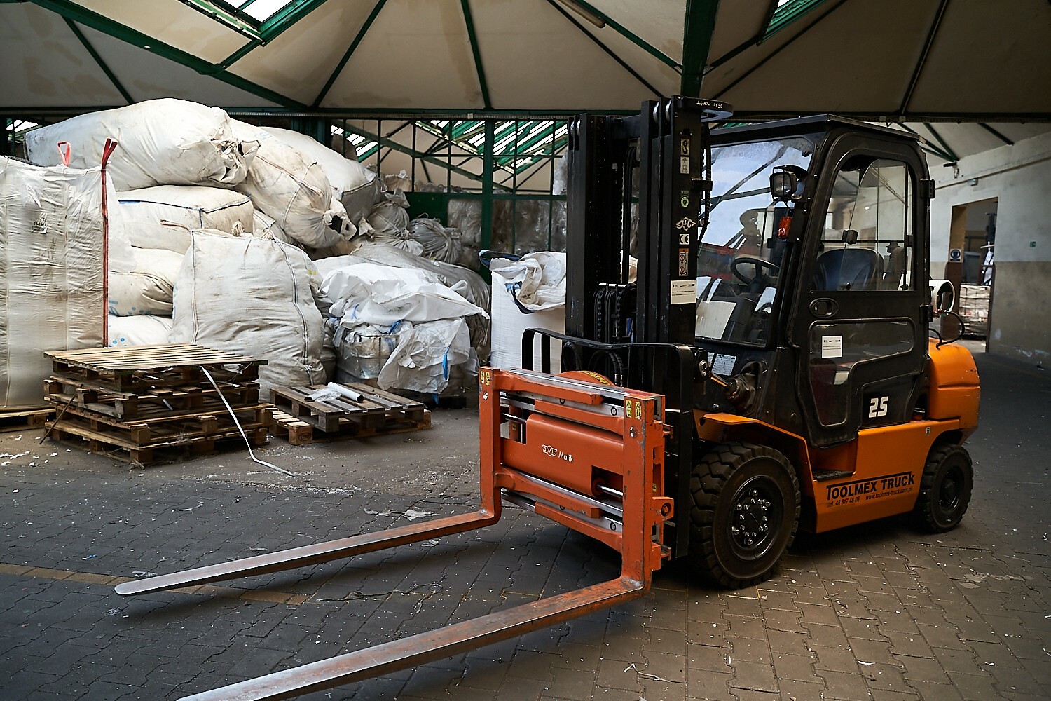 hala produkcyjna na pierwszym planie w&oacute;zek widłowy 